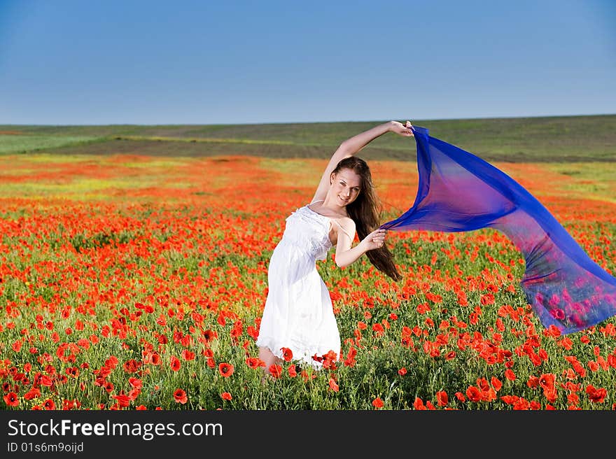 Smiling girl in white dress in the poppy field. Smiling girl in white dress in the poppy field