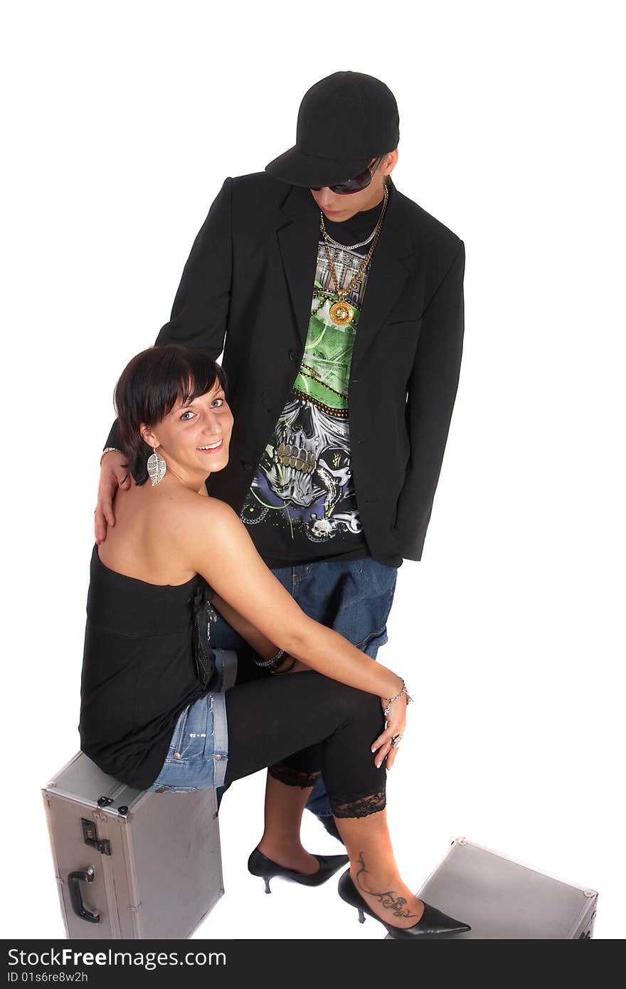 Young stylish couple isolated over white. She is sitting on dj cases. Young stylish couple isolated over white. She is sitting on dj cases.