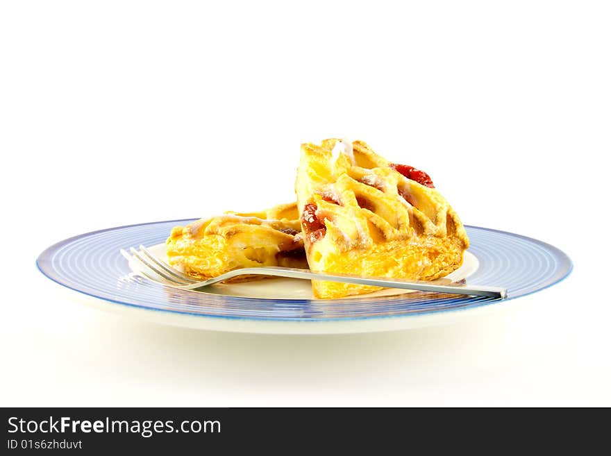 Raspberry and custard danish on a blue and white plate with a fork on a white background. Raspberry and custard danish on a blue and white plate with a fork on a white background