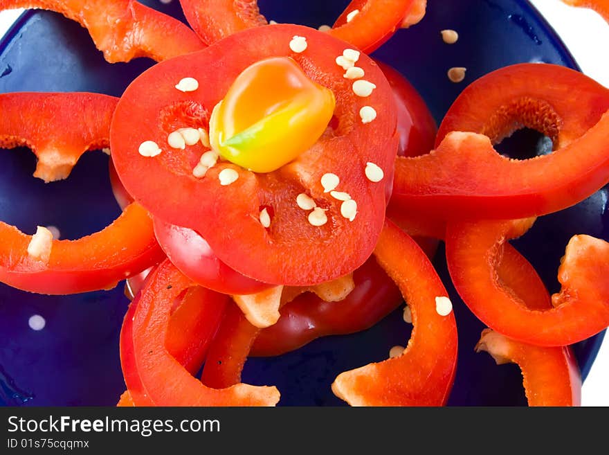 Sliced fresh red pepper on blue dish. Sliced fresh red pepper on blue dish