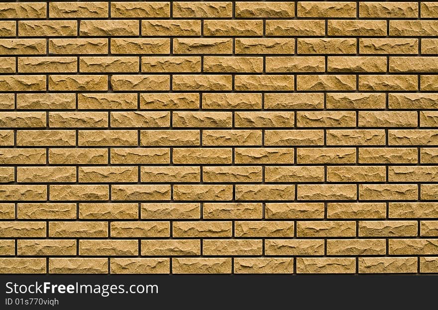 Even yellow, rough brick wall