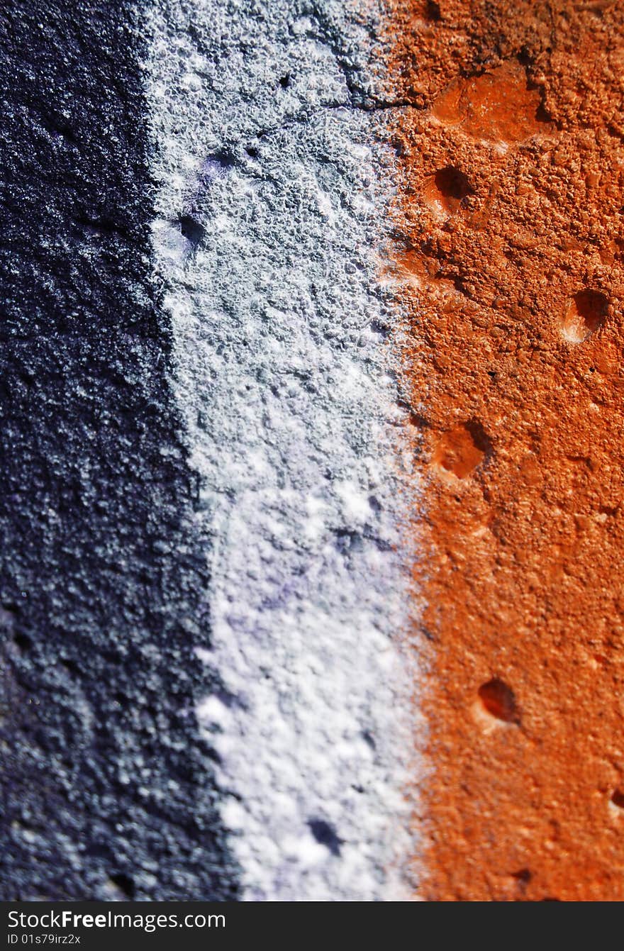 Blue, white and orange graffiti on a concrete wall. Blue, white and orange graffiti on a concrete wall.