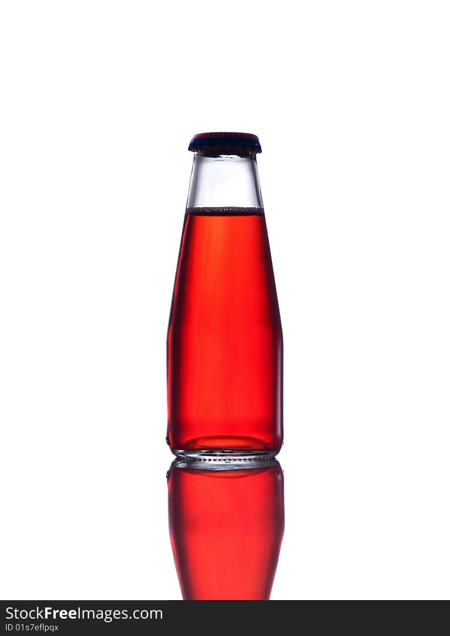 Red drink  in bottle closed with cap, white background and reflection.