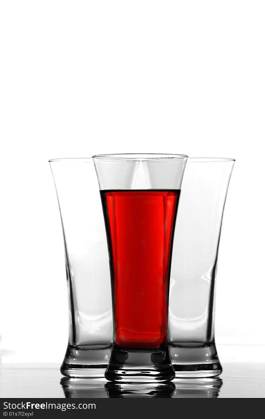 Three glasses one filled with red color