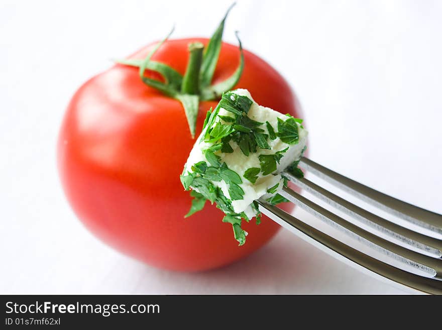 Cheese cube and tomato on white background