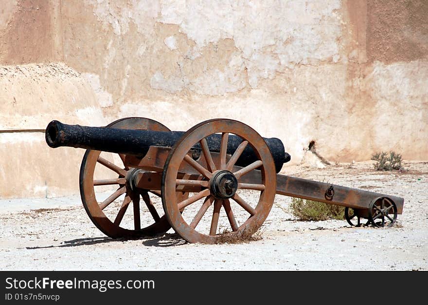 A cannon on guard next to a wall. A cannon on guard next to a wall