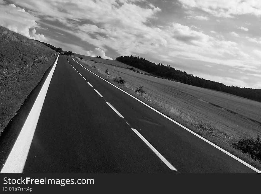 Diagonal line of a new road under dramatic sky in black and white. Diagonal line of a new road under dramatic sky in black and white