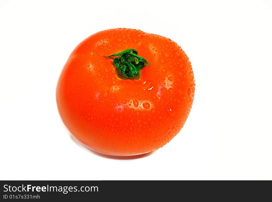 Large isolated tomato on a white background with shiny water droplets. Large isolated tomato on a white background with shiny water droplets