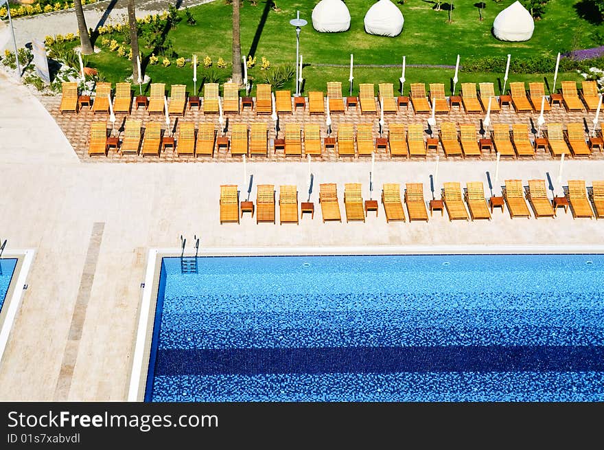 Sunbeds and umbrellas near resort's pool. Sunbeds and umbrellas near resort's pool