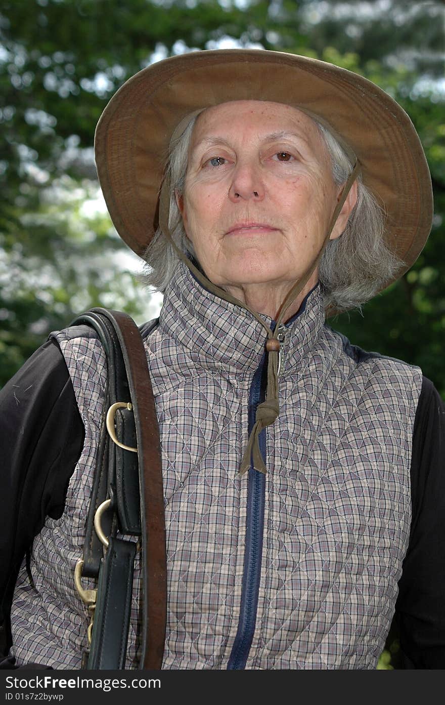 Color photograph of a senior woman about to saddle up her horse and go out for a ride. Color photograph of a senior woman about to saddle up her horse and go out for a ride.