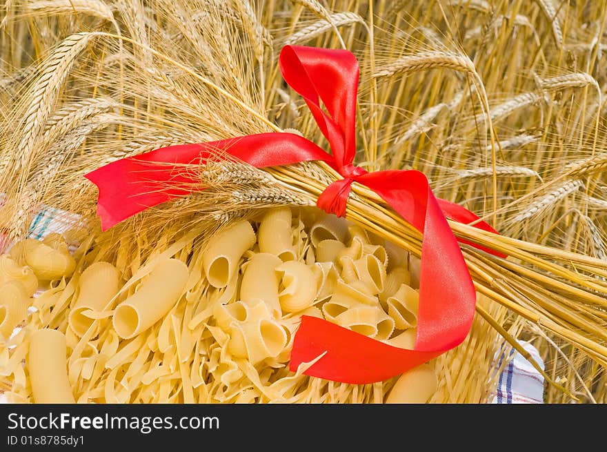 Noodles, macaroni and wheat stalks on a table in the field. Noodles, macaroni and wheat stalks on a table in the field.