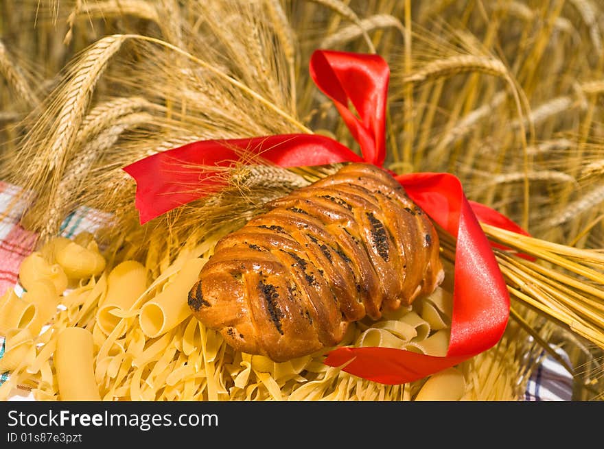 Noodles, macaroni and wheat stalks on a table in the field. Noodles, macaroni and wheat stalks on a table in the field.