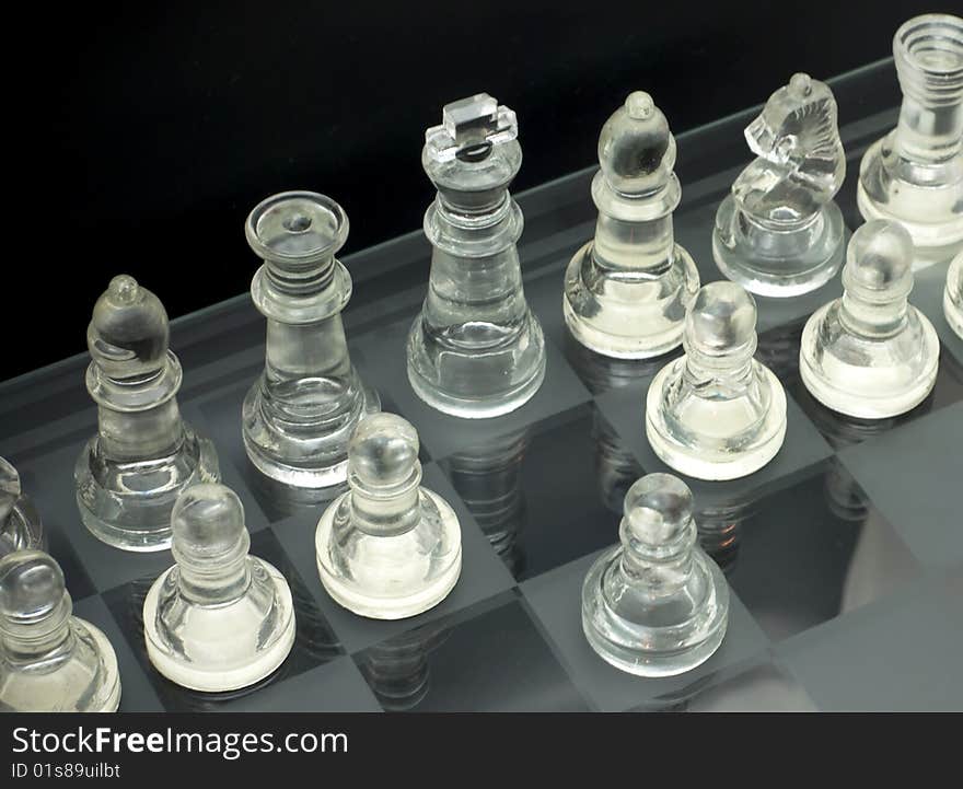 Glass chess is placed on a black background