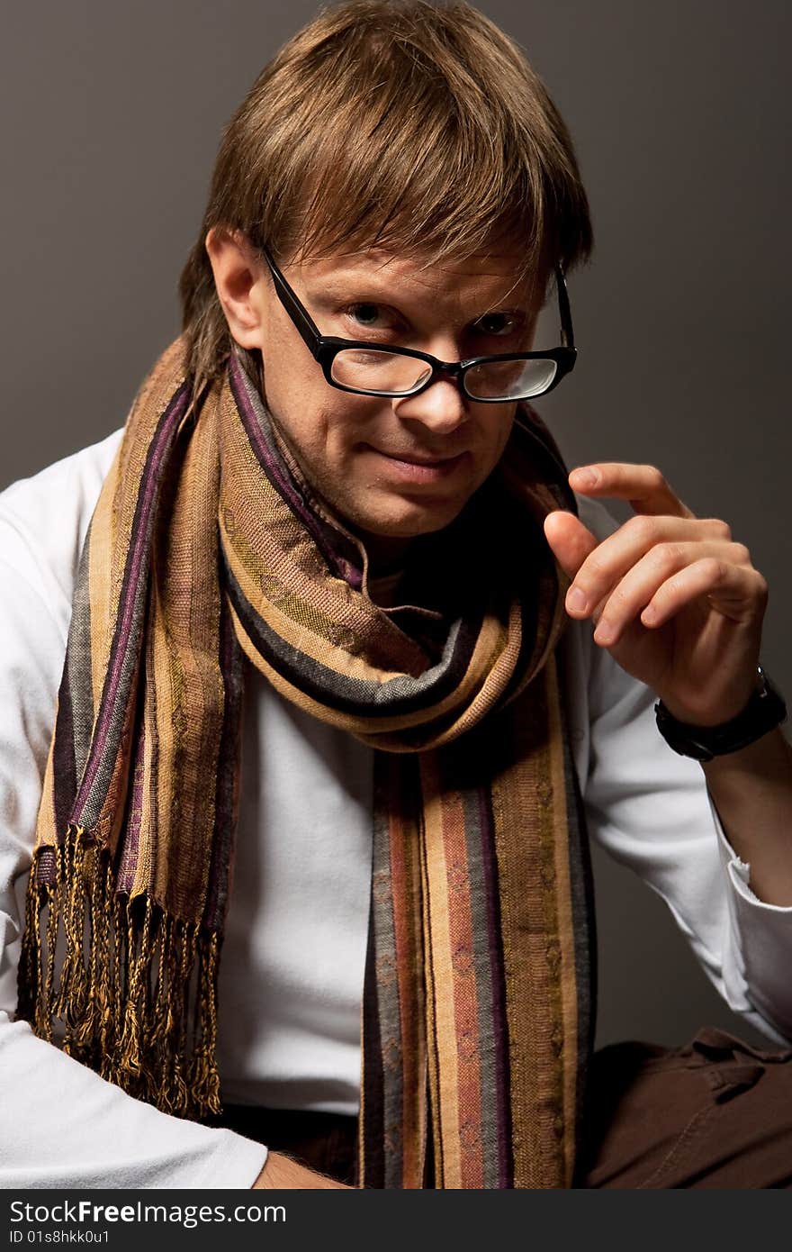 Man with scarf touching glasses isolated