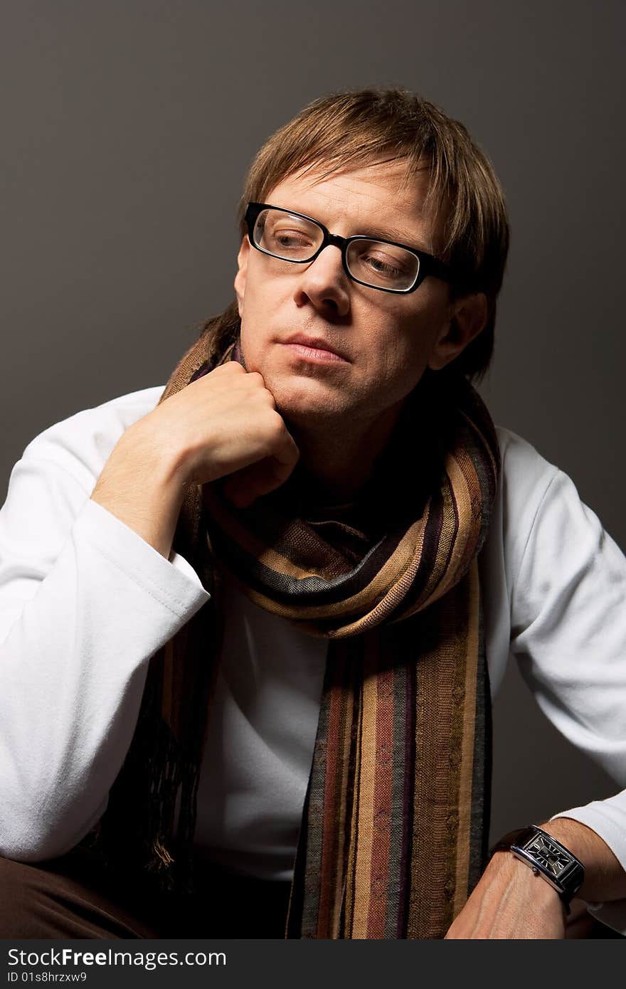 Man thinking in glasses with scarf isolated over gray