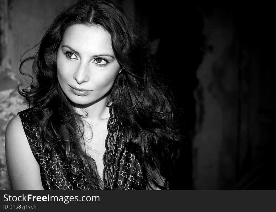 Expressive portrait of young woman on old wall background