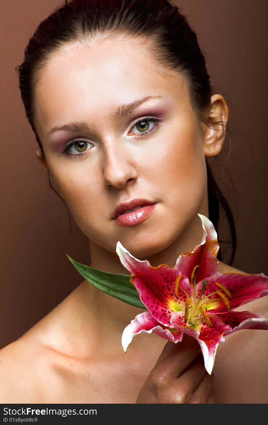 Beauty portrait of a young woman with a lily flower. Beauty portrait of a young woman with a lily flower