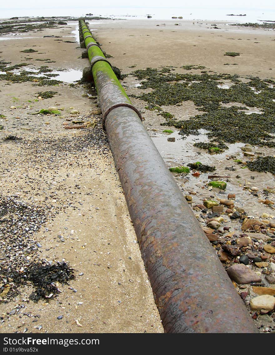 A stormwater pipe stretching across the sands towards the sea. A stormwater pipe stretching across the sands towards the sea