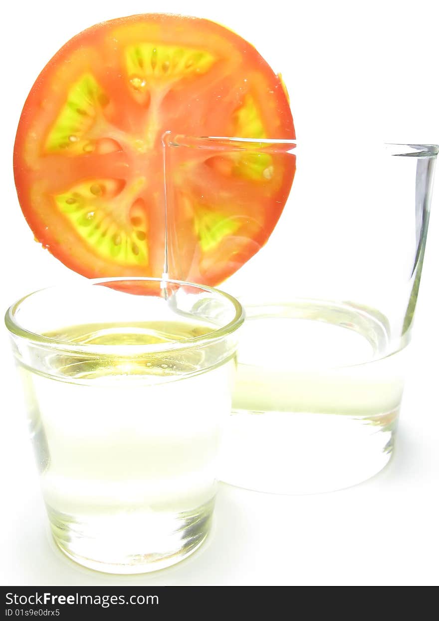 Glass of sunflower oil and tomatoesfast  food, white background. Glass of sunflower oil and tomatoesfast  food, white background.