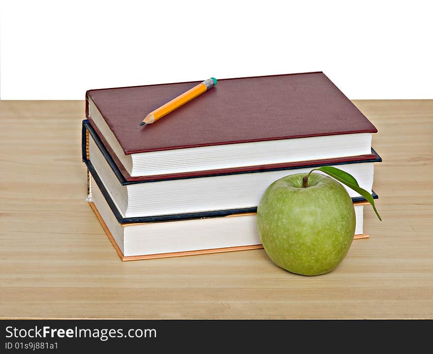 Apple and pencil on top of books