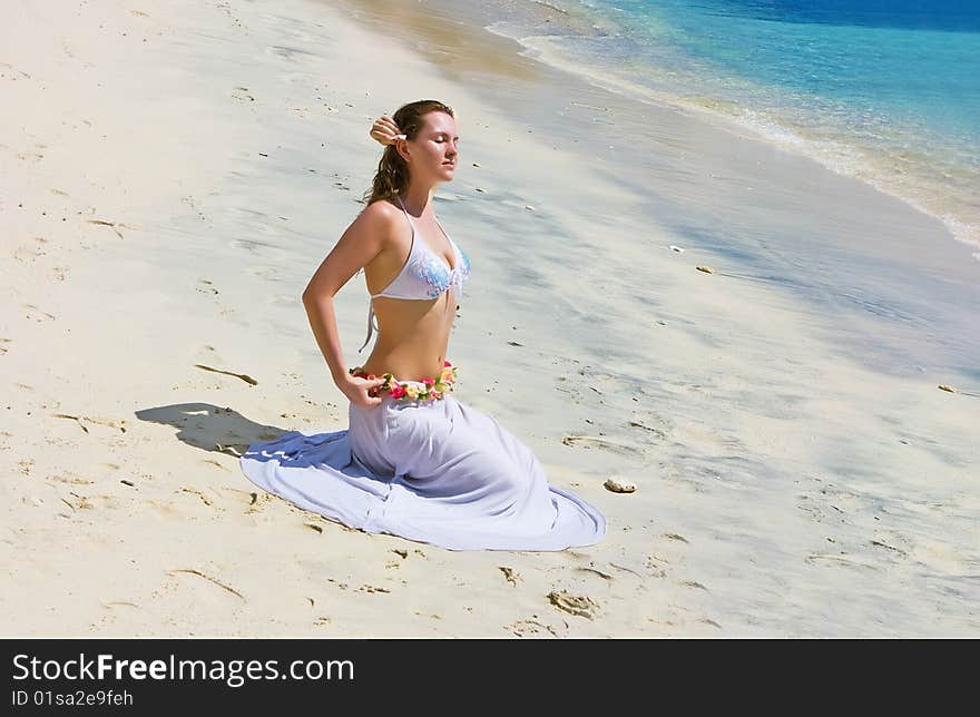 Brunette Girl Sitting On Sand Beach