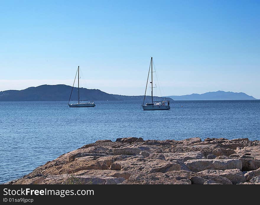 Two yachts swiming in a the blue water of the mediteranean sea. Two yachts swiming in a the blue water of the mediteranean sea