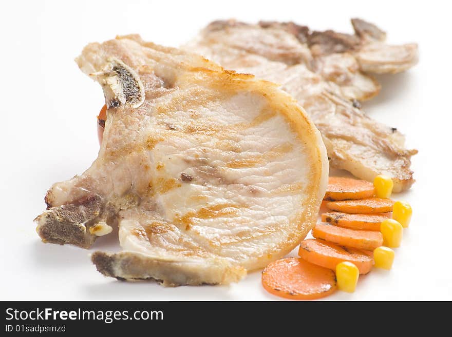 Tasty pork chop with corn carrot tomato isolated