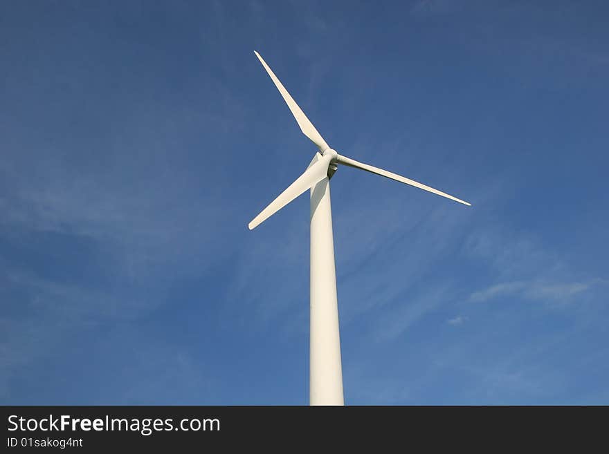 White wind turbine in front of blue sky