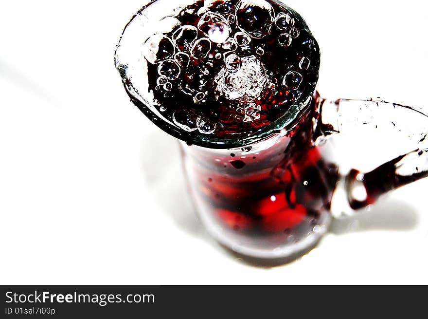 A carafe full with sour-cherries and water on white background. A carafe full with sour-cherries and water on white background