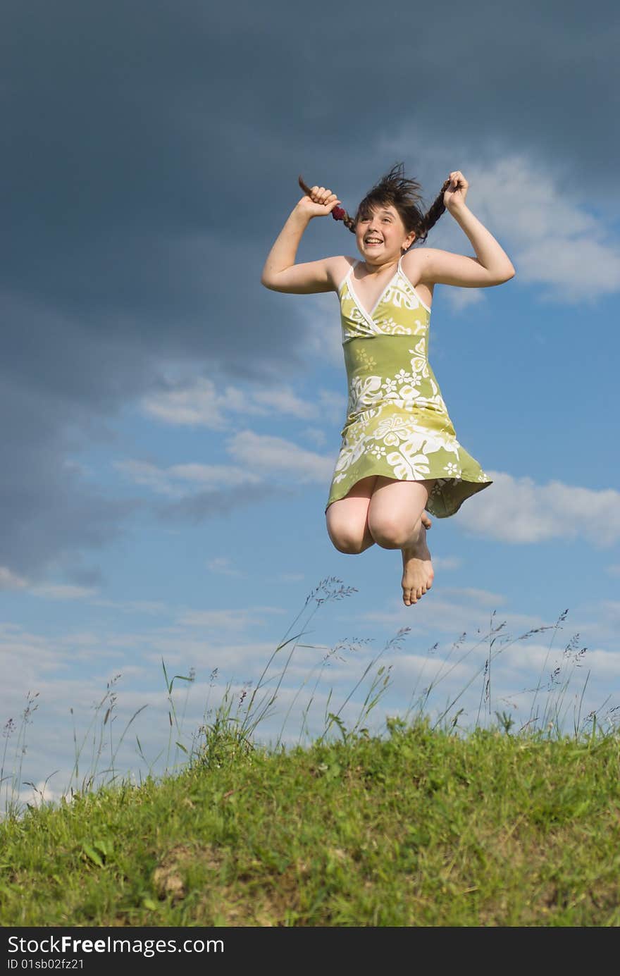 Jumping girl on the green hill (summer)