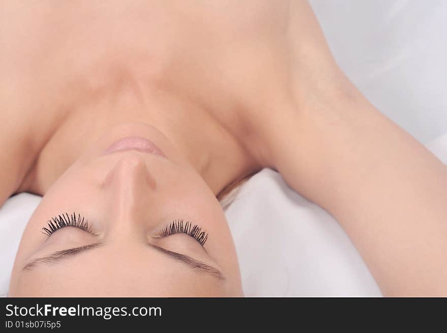 Portrait of the fresh and beautiful girl laying on a white background