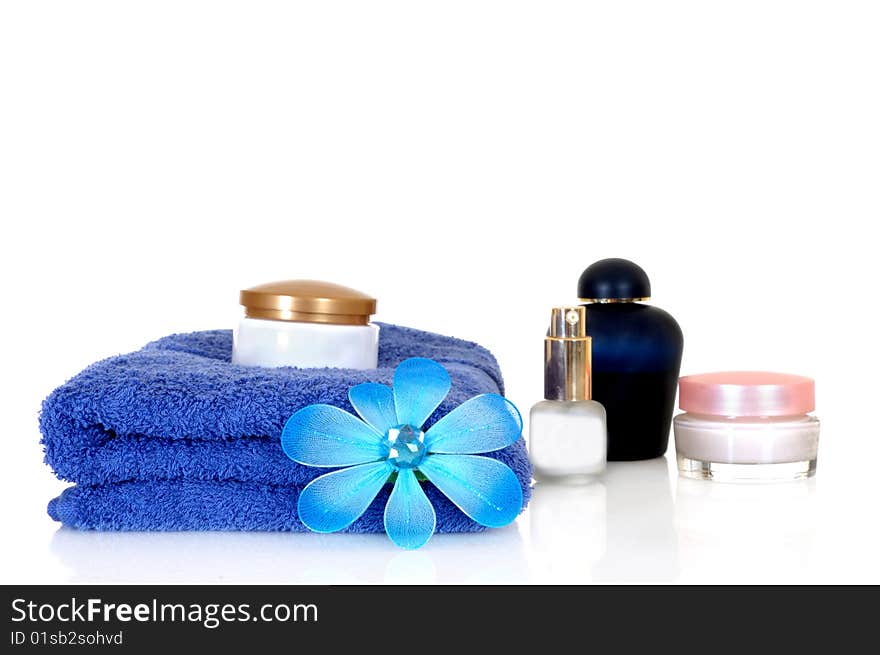 Spa essentials in blue on white background, reflective surface. Spa essentials in blue on white background, reflective surface