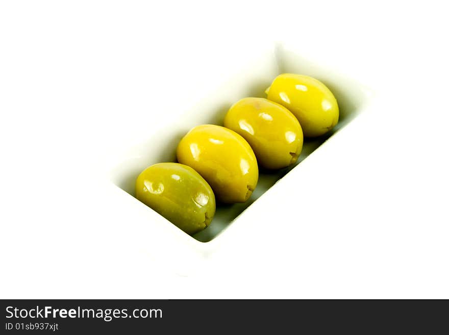 Four green olives in a small dish on a white background. Four green olives in a small dish on a white background