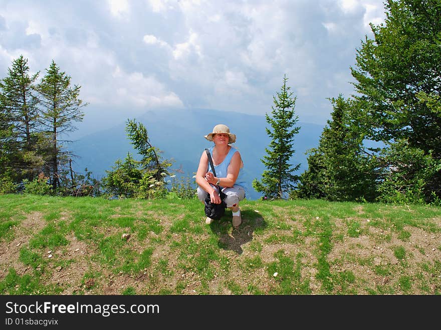 The Alpes. Italy. Solar summer day. A smoke. The having a rest woman against mountain tops. The Alpes. Italy. Solar summer day. A smoke. The having a rest woman against mountain tops.