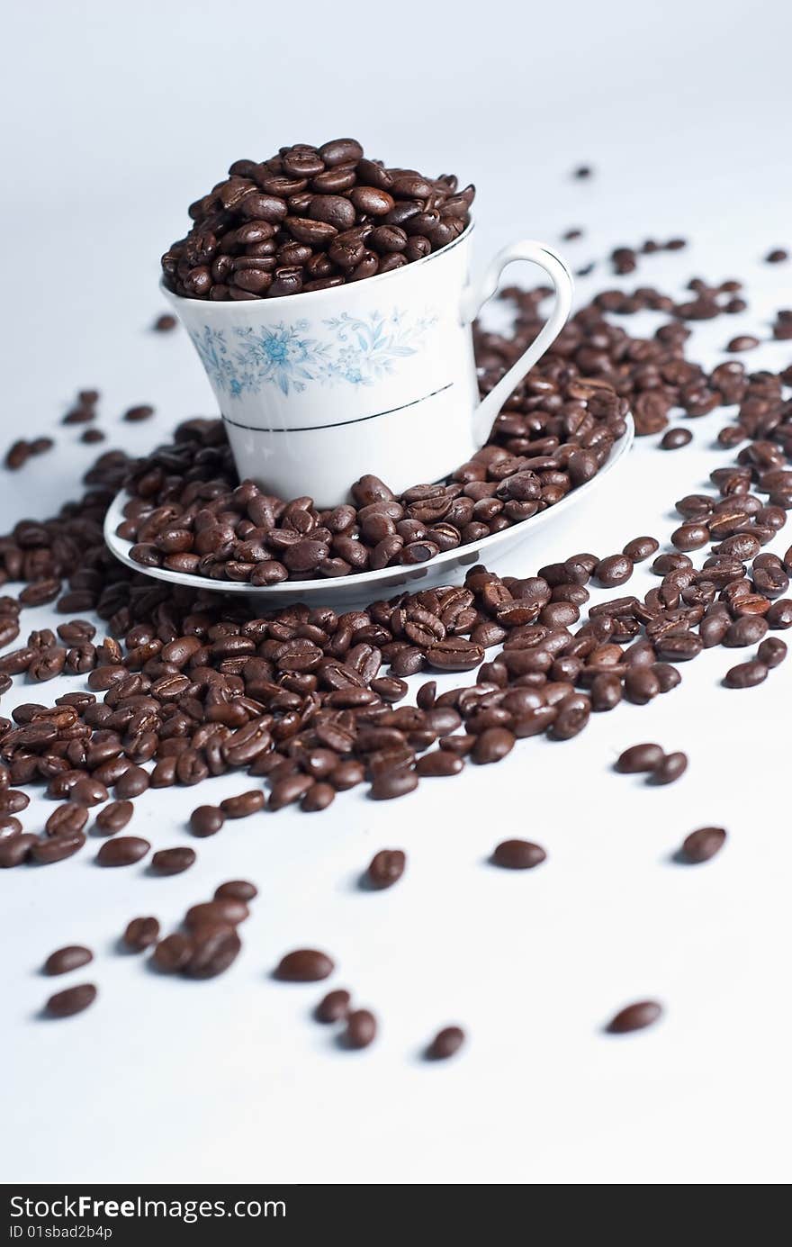 Cup of coffee beans on white background