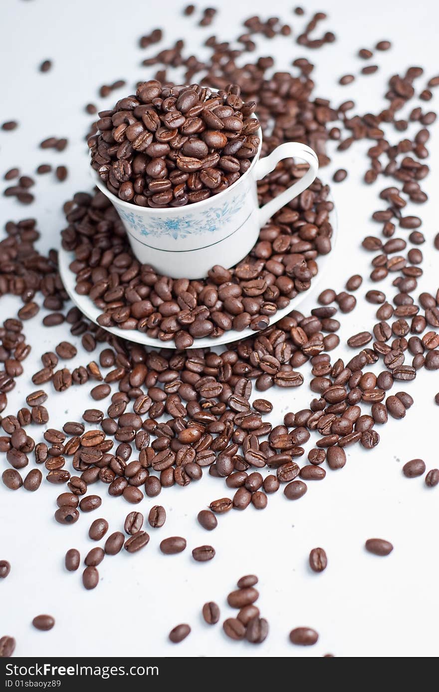 Cup of coffee beans on white background