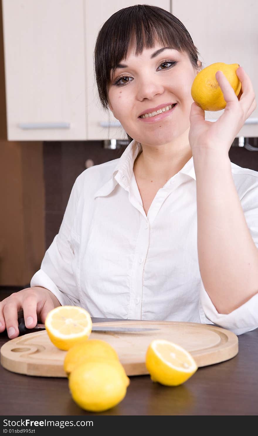 Young brunette woman making lemon juice