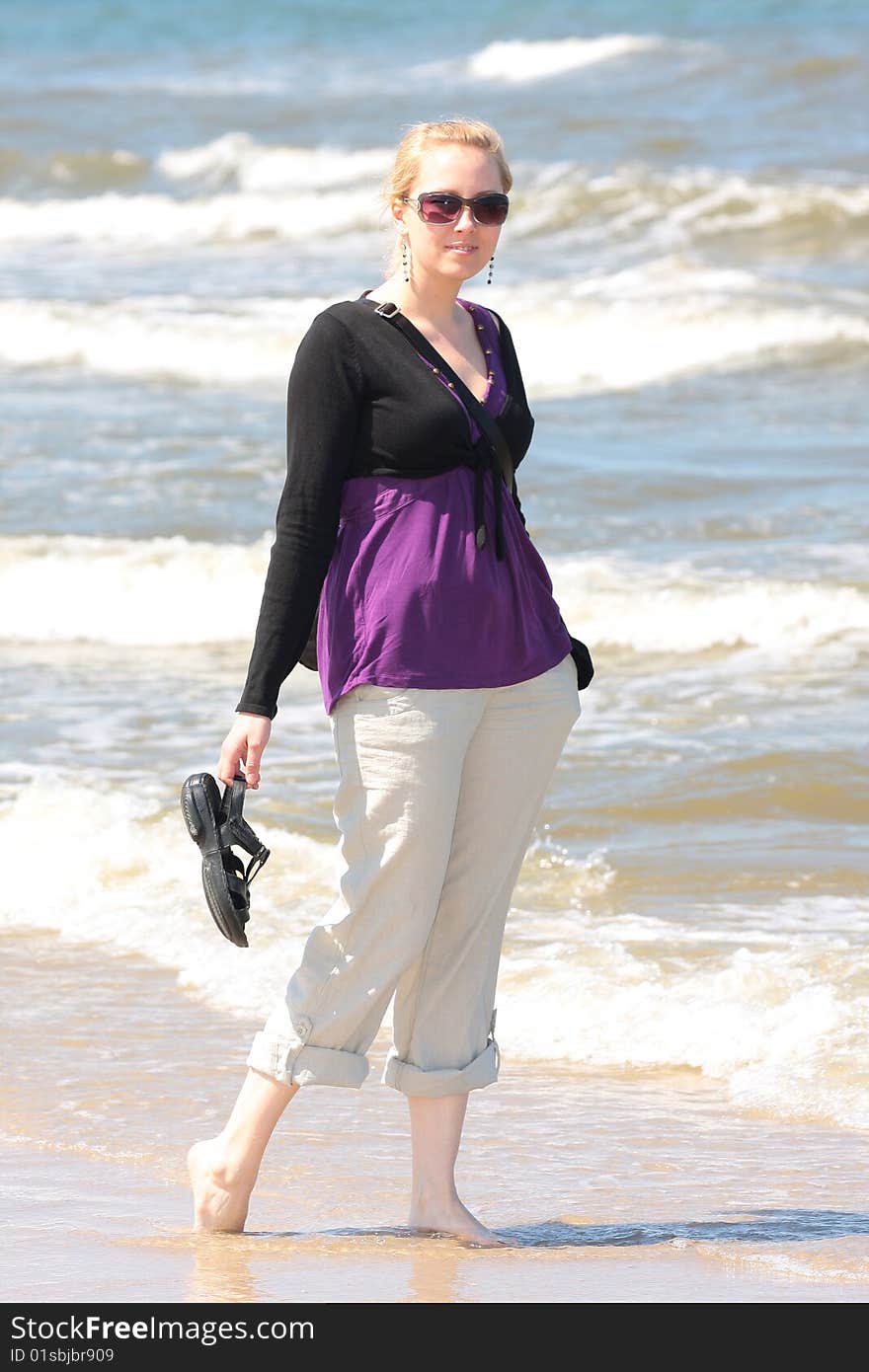 Blond smiling girl walking on the beach. Blond smiling girl walking on the beach