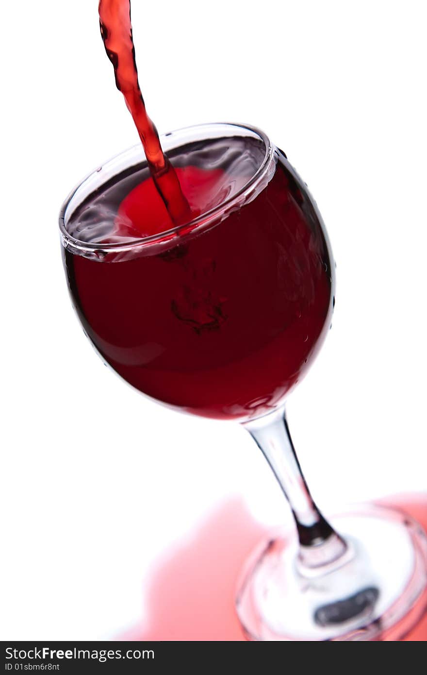 Red wine pouring into glass isolated over white