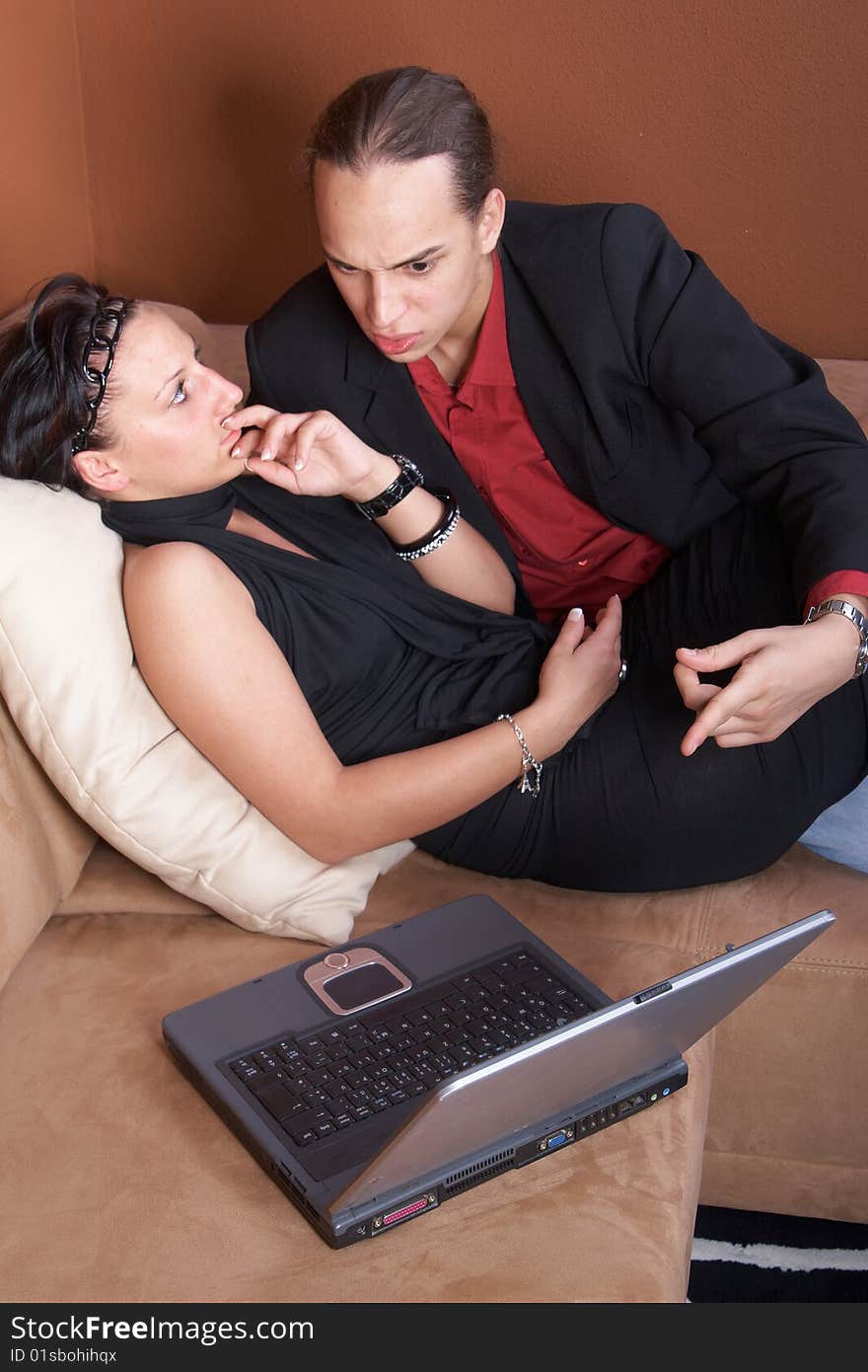 Young couple on the couch surfing the web with their laptop. Young couple on the couch surfing the web with their laptop.