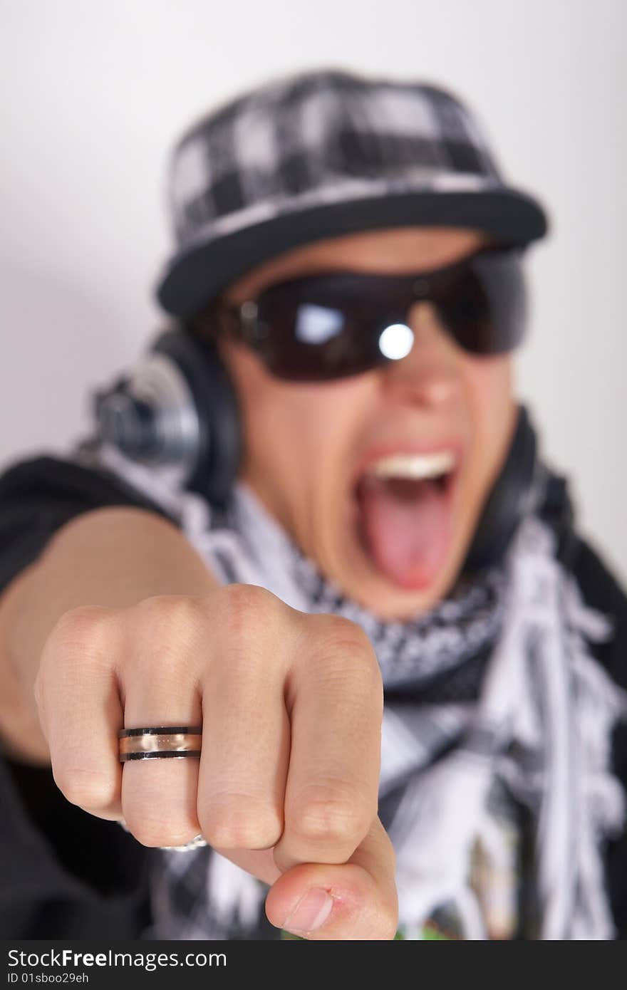 A young DJ is pointing at the camera and screaming. The focus is on his fist! Isolated over white. A young DJ is pointing at the camera and screaming. The focus is on his fist! Isolated over white.