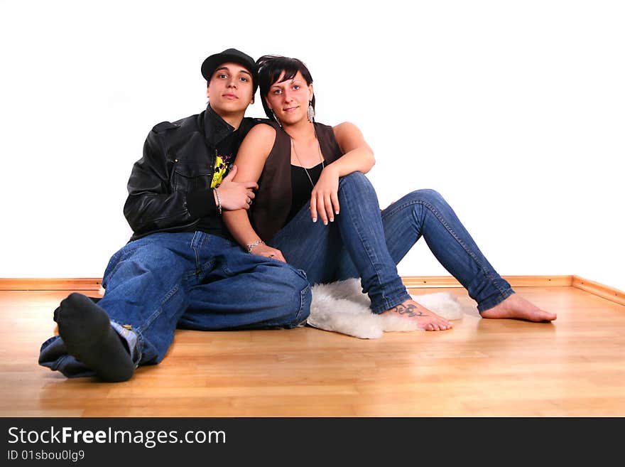 Young stylish couple sitting on the floor of their new home! Pure white wall leaves big copyspace. Young stylish couple sitting on the floor of their new home! Pure white wall leaves big copyspace.