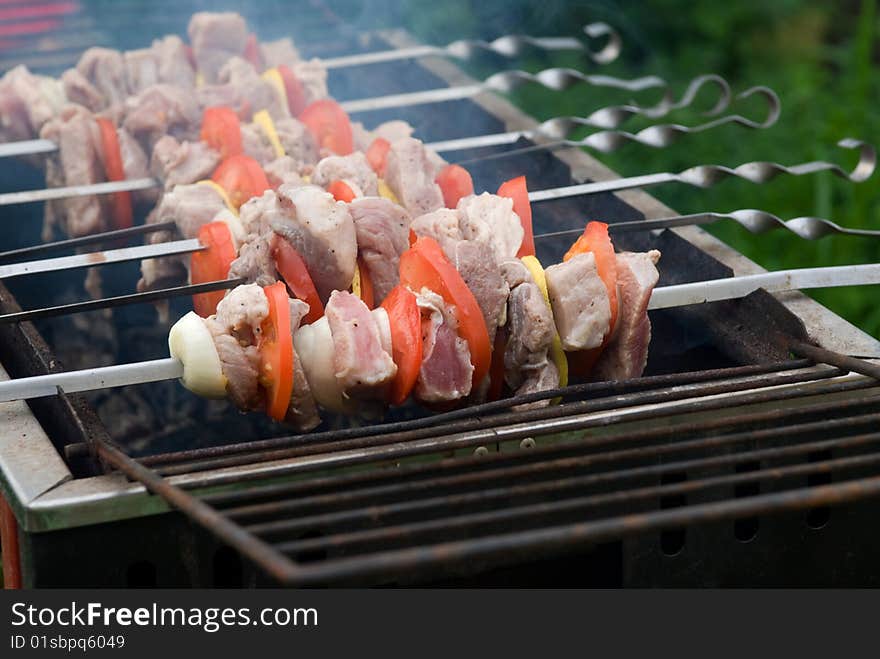 Shish kebab preparation on a brazier. Outdoor picnic.