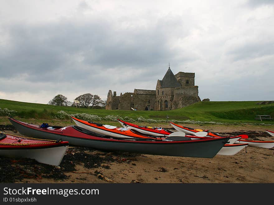 Several canoes drawn up in front of an old building. Several canoes drawn up in front of an old building