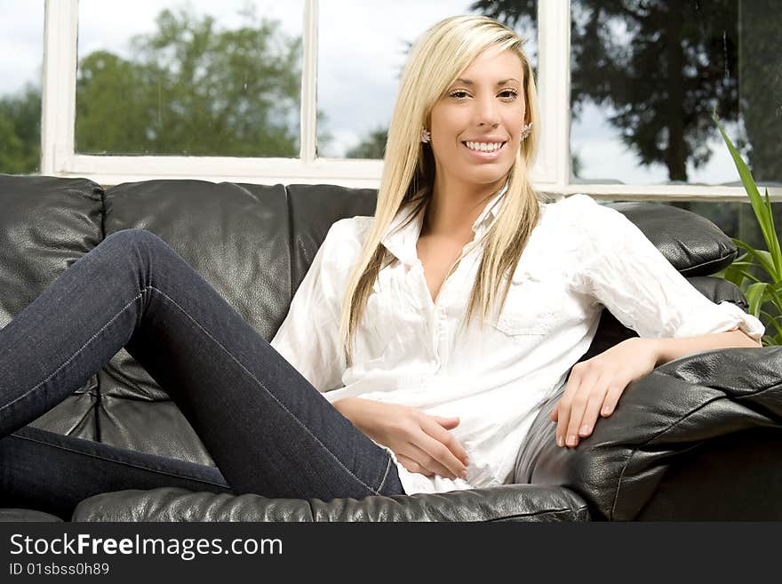 Female model in sitting room setting on sofa. Female model in sitting room setting on sofa