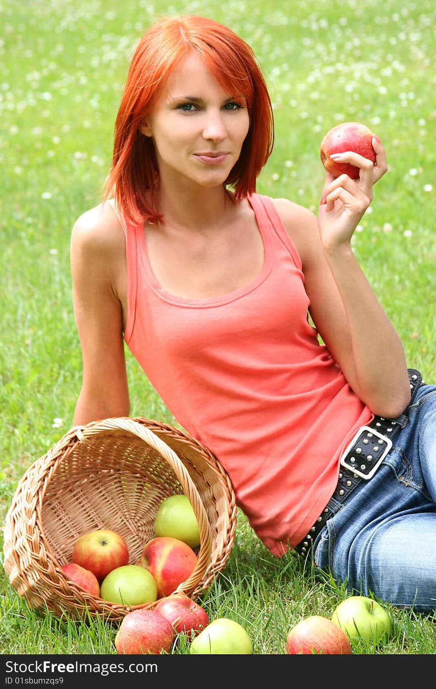 Beautiful girl with a basket of apples on a meadow. Beautiful girl with a basket of apples on a meadow