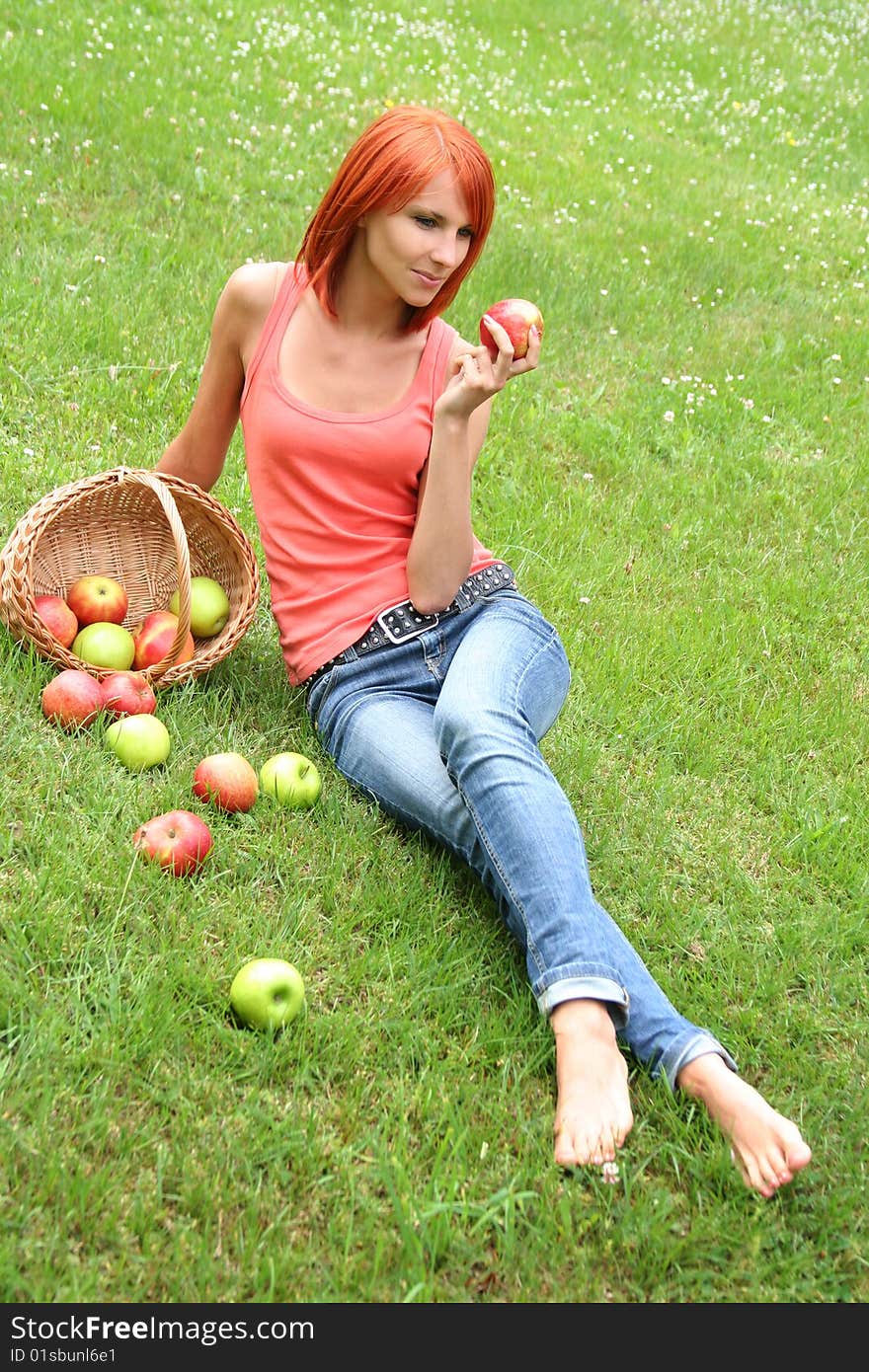 Beautiful girl with a basket of apples on a meadow. Beautiful girl with a basket of apples on a meadow