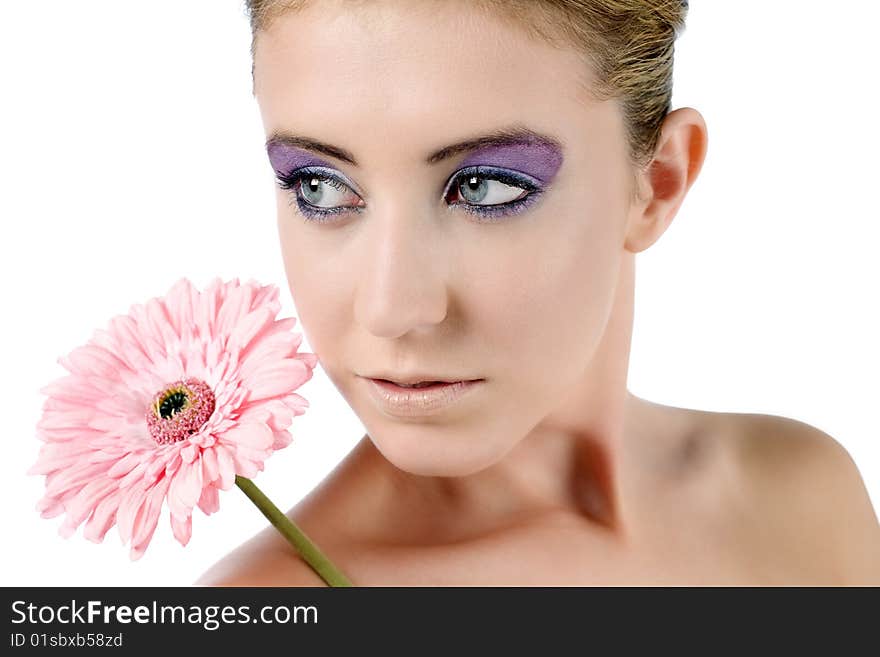 Female model holding a pink flower with strong eye makeup, on a white background. Female model holding a pink flower with strong eye makeup, on a white background