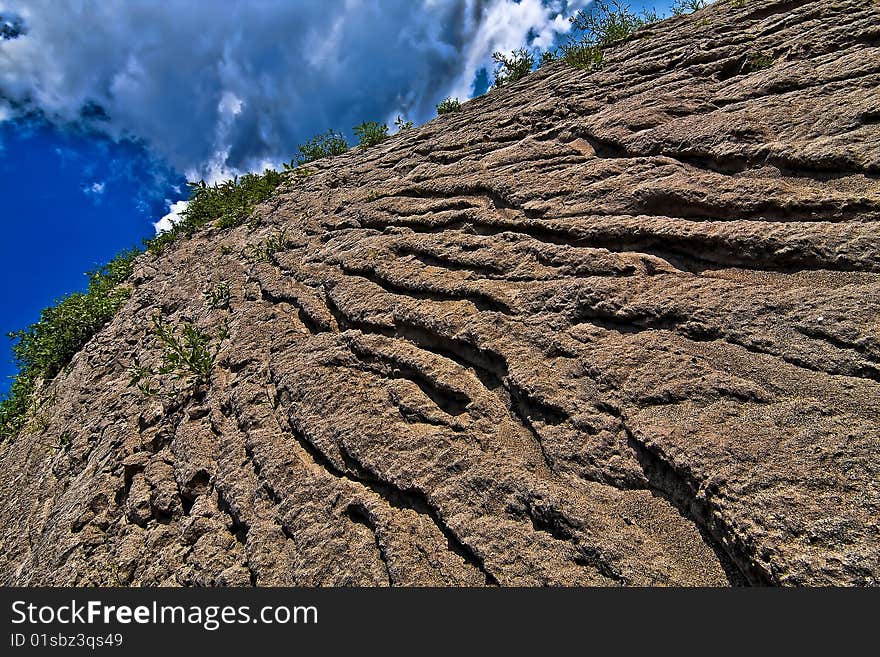 Cracked sand mountain with deep ridges created by rains. Cracked sand mountain with deep ridges created by rains.