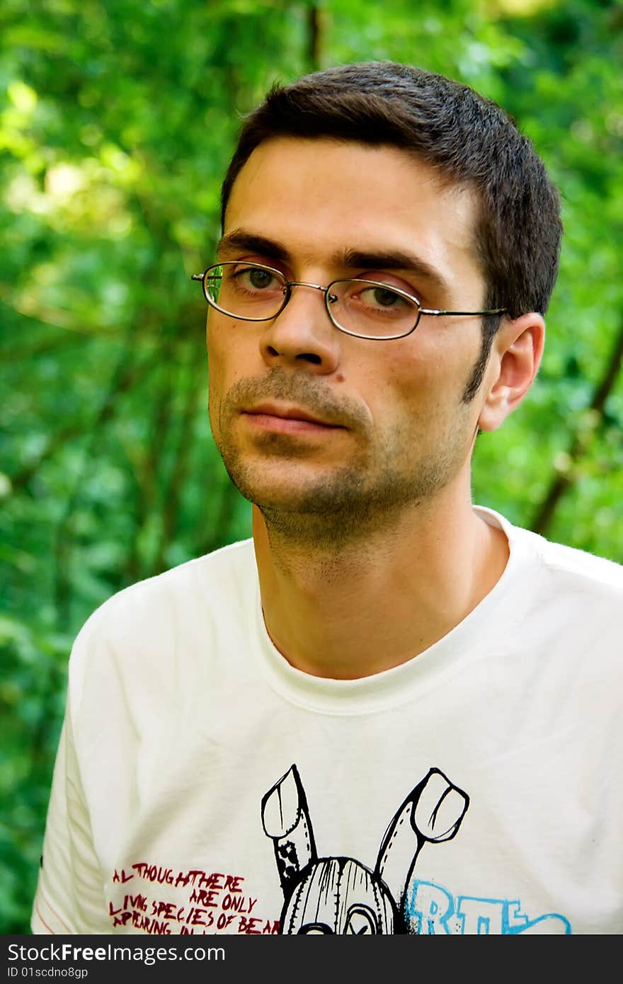 Portrait of young male in glasses and white t-shirt in the forest. Portrait of young male in glasses and white t-shirt in the forest